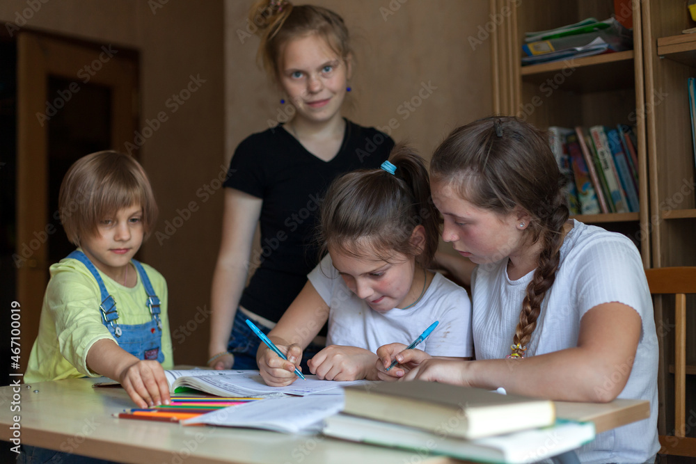 .girls doing homework at table .girls doing homework at table