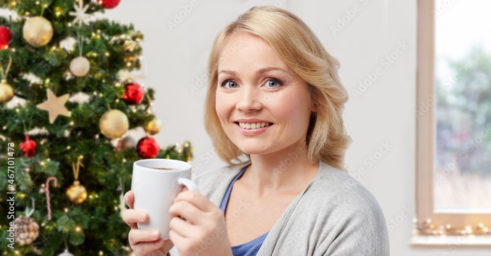 winter holidays, people and leisure concept - smiling woman drinking coffee or tea at home over christmas tree background winter holidays, people and leisure concept - smiling woman drinking coffee or tea at home over christmas tree background