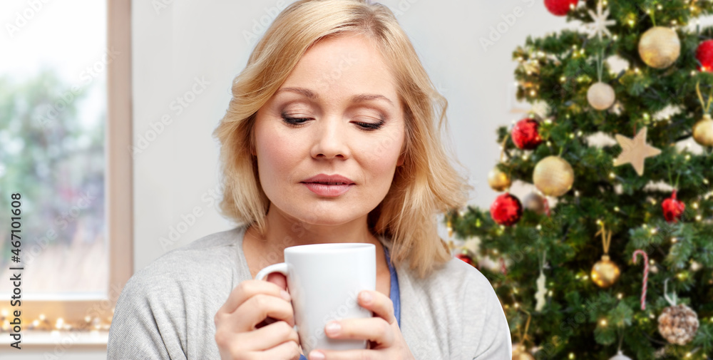winter holidays, people and leisure concept - woman drinking coffee or tea at home over christmas tree background winter holidays, people and leisure concept - woman drinking coffee or tea at home over christmas tree background