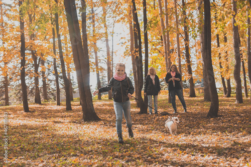 Grandmother and mother with granddaughter walks together in autumn park and having fun. Generation, leisure and family concept. © satura_