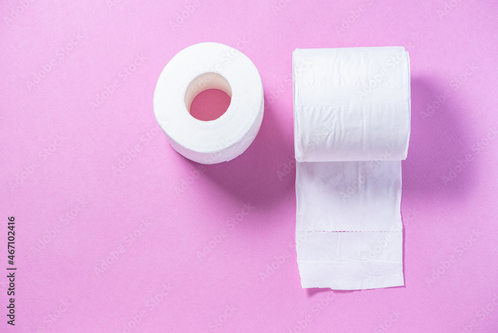 Obraz premium Eco-friendly white toilet paper on a pink background close-up