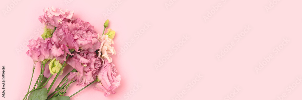 Banner with bouquet of eustoma flowers on a pink background.