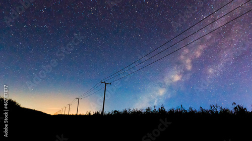 abstract night sky with milky way and star over the silhouette power line.