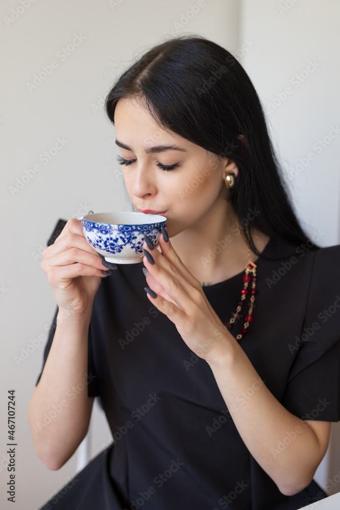 Elegant woman in black drinking tea Elegant woman in black drinking tea