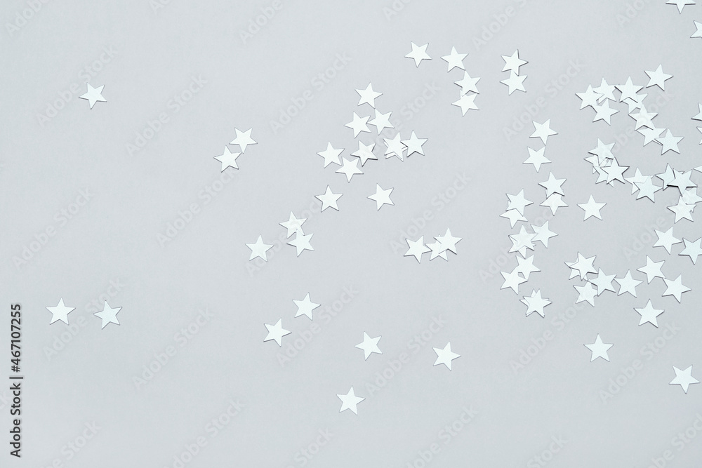 Silver stars confetti on gray background. Christmas or winter festive background Silver stars confetti on gray background. Christmas or winter festive background