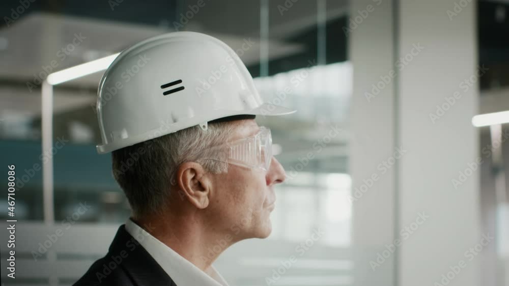Successful Businessman Investor Wearing Protective Glasses And Helmet Standing Indoors Successful Businessman Investor Wearing Protective Glasses And Helmet Standing Indoors