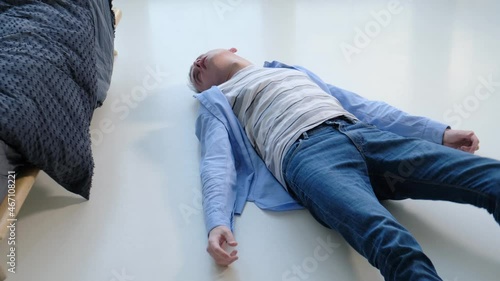 Epileptic seizure with convulsions in a man lying on the floor photo