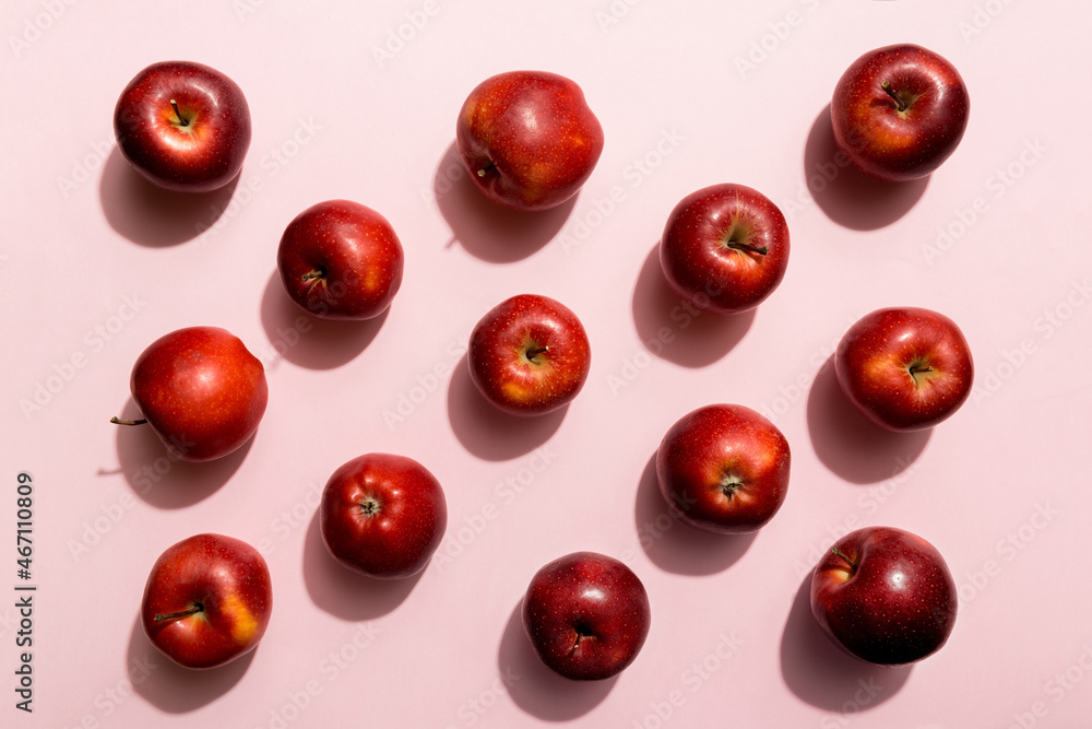 Many red apples on colored background, top view. Autumn pattern with fresh apple above view Many red apples on colored background, top view. Autumn pattern with fresh apple above view