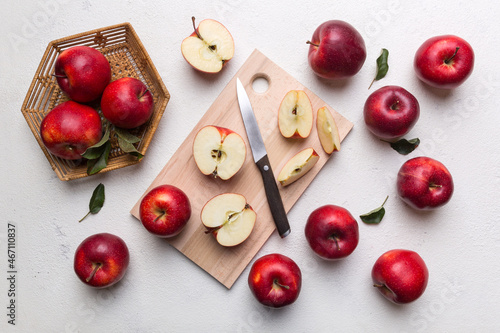 Fresh red apples with green leaves on table. cutting board with knife. Top view