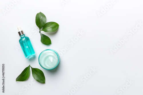 Organic cosmetic products with green leaves on white background. Copy space, flat lay © sosiukin