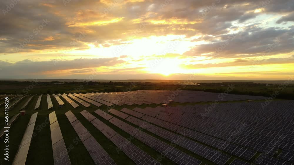Aerial view of big sustainable electric power plant with rows of solar photovoltaic panels for producing clean ecological electrical energy at sunset. Renewable electricity with zero emission concept Aerial view of big sustainable electric power plant with rows of solar photovoltaic panels for producing clean ecological electrical energy at sunset. Renewable electricity with zero emission concept