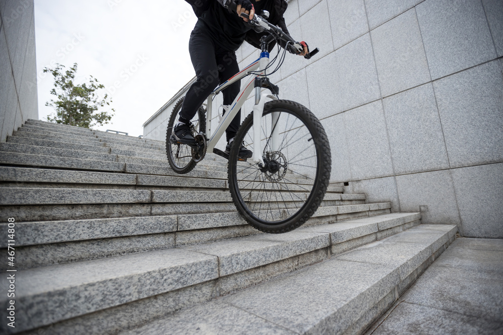Naklejka premium Woman freerider riding down city stairs