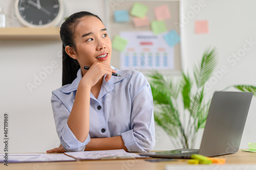 female worker using laptop and thinking