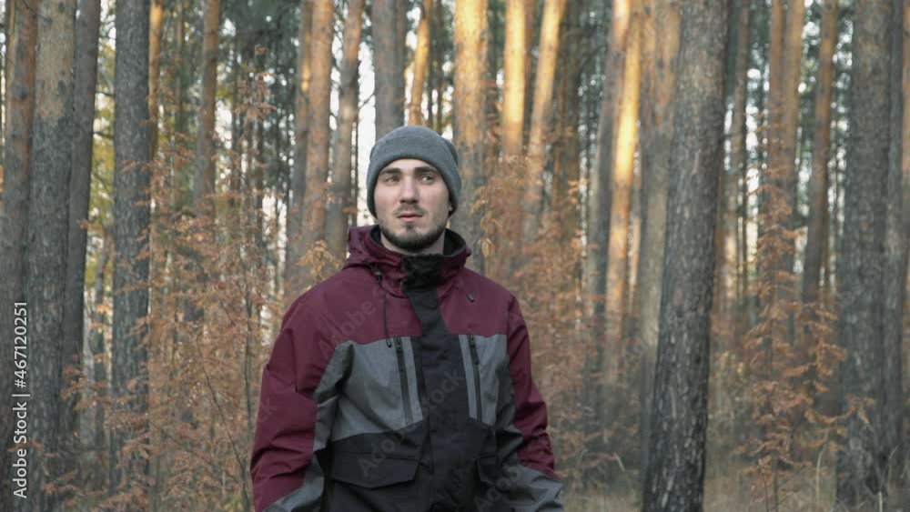 A man in a hat walks through the woods. Portrait of a young male traveler. Forester walking through the forest A man in a hat walks through the woods. Portrait of a young male traveler. Forester walking through the forest