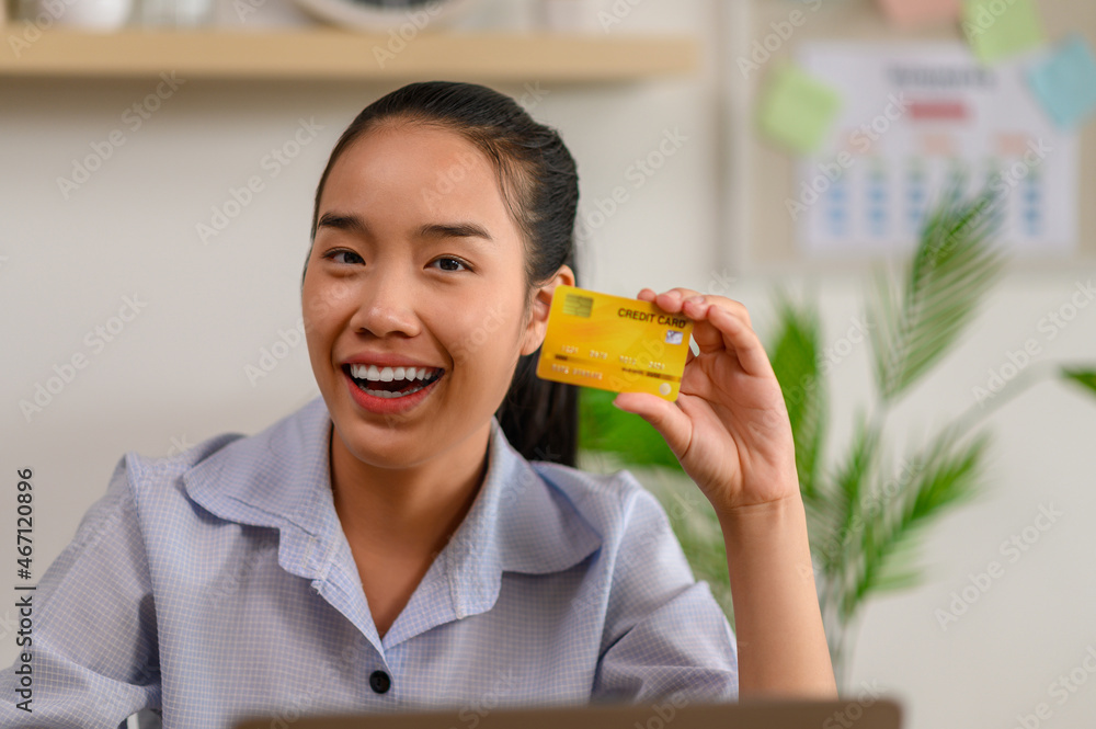 female employee holding credit card in office female employee holding credit card in office