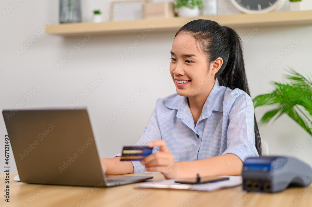 female employee holding credit card in office female employee holding credit card in office