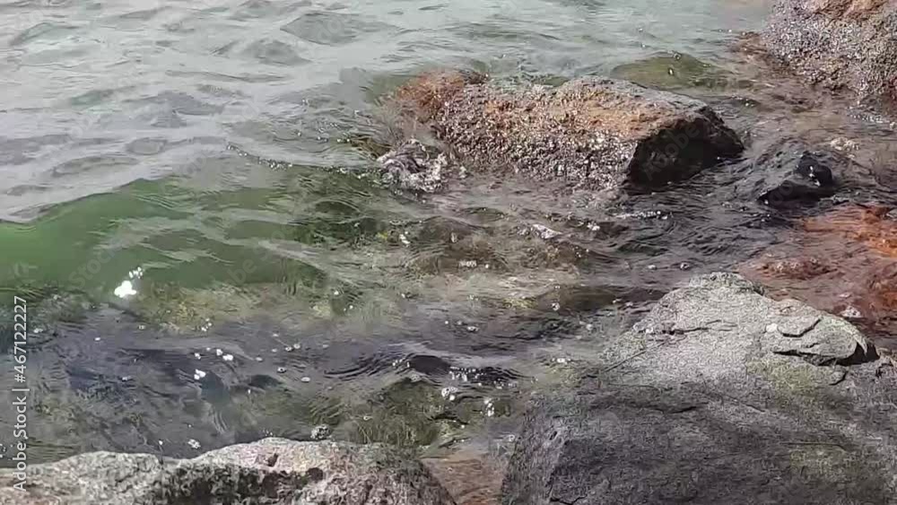 Small waves hit small rocks on the beach Small waves hit small rocks on the beach
