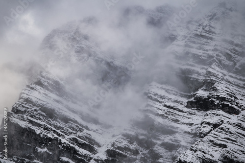 snow covered mountain wall in the fog