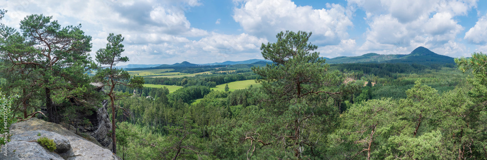 Panoramic view from sandstone rock viewpoint Havrani skaly, spring landscape in Lusatian Mountains with hill Klic, Kleis, green hills, fresh deciduous and spruce tree forest. Blue sky background, copy