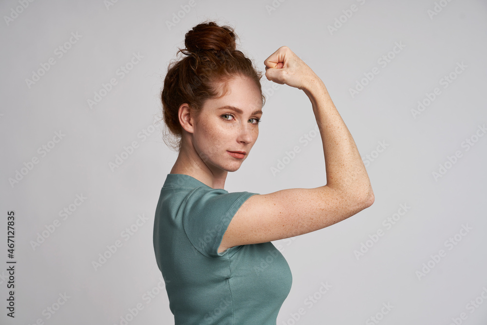 © gpointstudio - Young woman showing sign of girl power