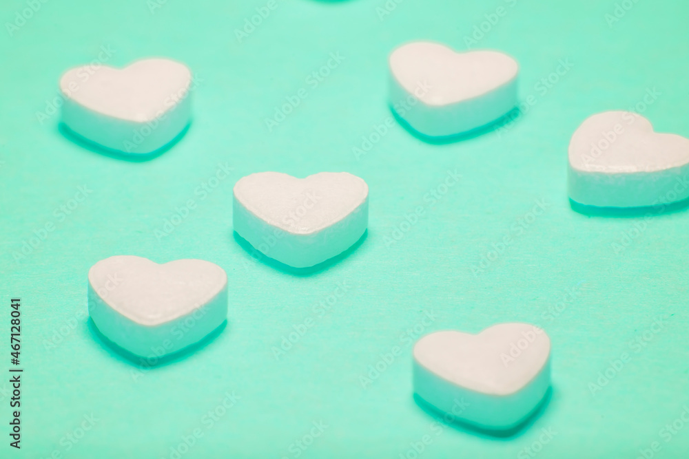 Heart shaped pills on a green background. Medicines for the heart and for blood vessels and lungs. Heart shaped pills on a green background. Medicines for the heart and for blood vessels and lungs.
