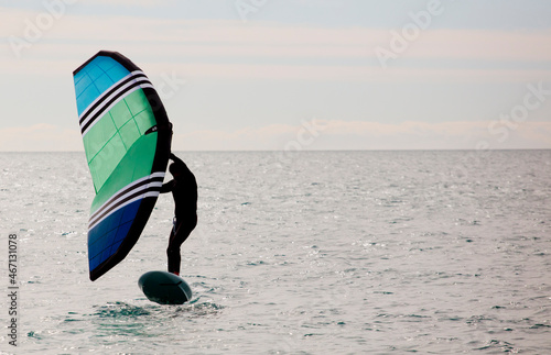 sportsman with wingfoil sailing, in the sea photo