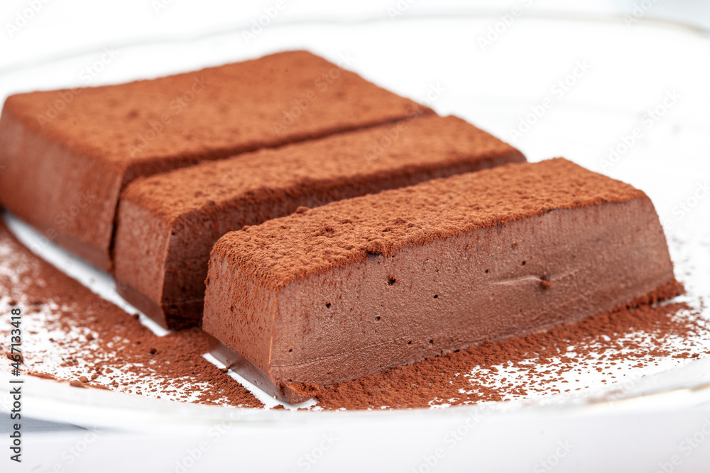 Chocolate mousse cake on a white plate. Soufflé made from cocoa liquor, coconut milk and agar-agar. Vegan desserts Chocolate mousse cake on a white plate. Soufflé made from cocoa liquor, coconut milk and agar-agar. Vegan desserts