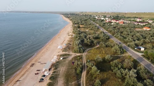 Aerial view of sandy beach during golden hour. Dolly shot.