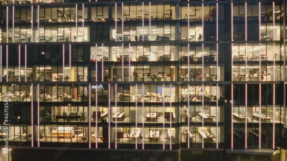Cinematic aerial view of the offices at night in a business center. Close-up aerial view of the skyscraper and offices at night, panorama to the right Cinematic aerial view of the offices at night in a business center. Close-up aerial view of the skyscraper and offices at night, panorama to the right