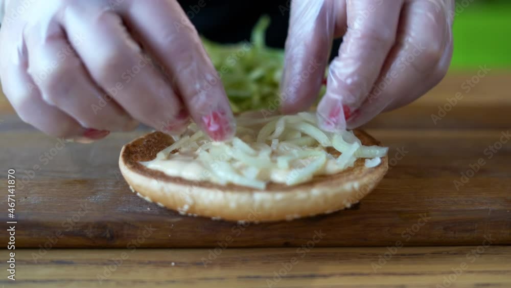Chef preparing a burger on a wooden board, American dinner fatty hamburger, the process of making a burger, hands making a sandwich. Chef preparing a burger on a wooden board, American dinner fatty hamburger, the process of making a burger, hands making a sandwich.