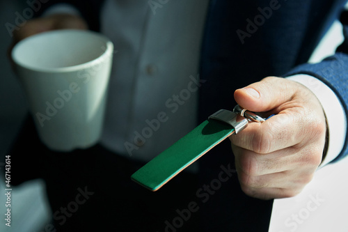 A man in a business suit with an electronic key and a cup. Blurred background. Ensuring the security of the company. Electronic document. photo