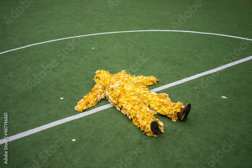 Woman wearing leaf costume lying at sports court photo