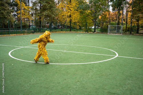 Woman wearing leaf costume running on sports field