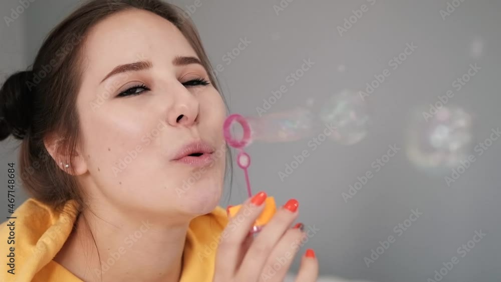 young woman girl in yellow making soap bubbles on grey background. happy, exited. slow motion. young woman girl in yellow making soap bubbles on grey background. happy, exited. slow motion.