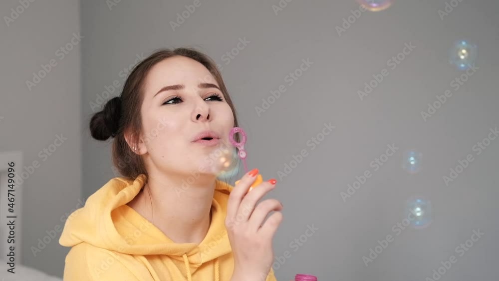 young woman girl in yellow making soap bubbles on grey background. happy, exited. slow motion. young woman girl in yellow making soap bubbles on grey background. happy, exited. slow motion.