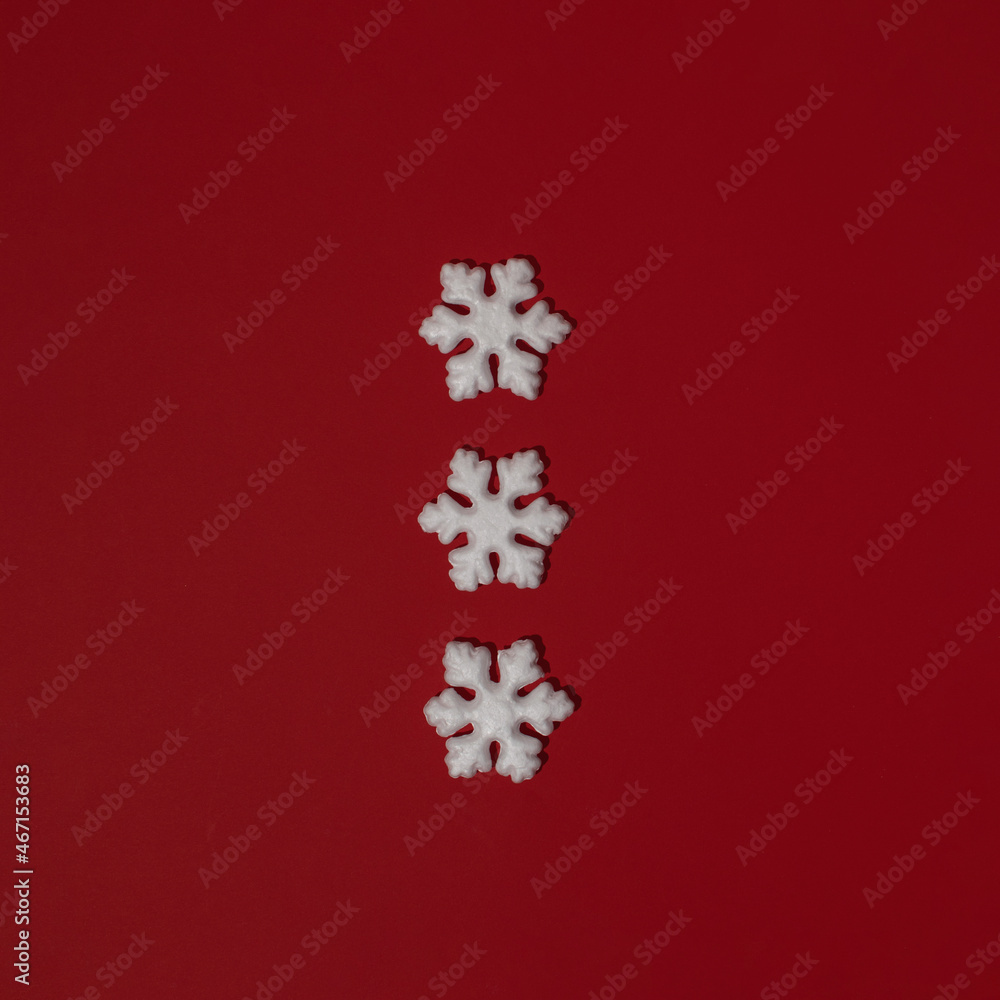Three white Christmas decorations against red background. Snowflakes, Santa Claus suit buttons idea. Greeting card.