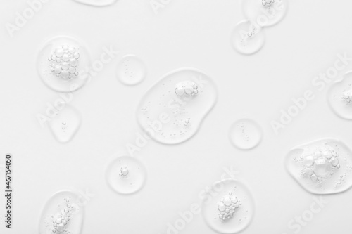 Cosmetic product transparent drops with bubbles on white surface close upper view. Skincare and dermatological procedures