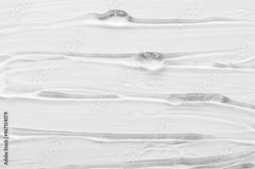 Texture of luxury gel cosmetic product smears as traces on white surface close upper view. Skincare and dermatological procedures