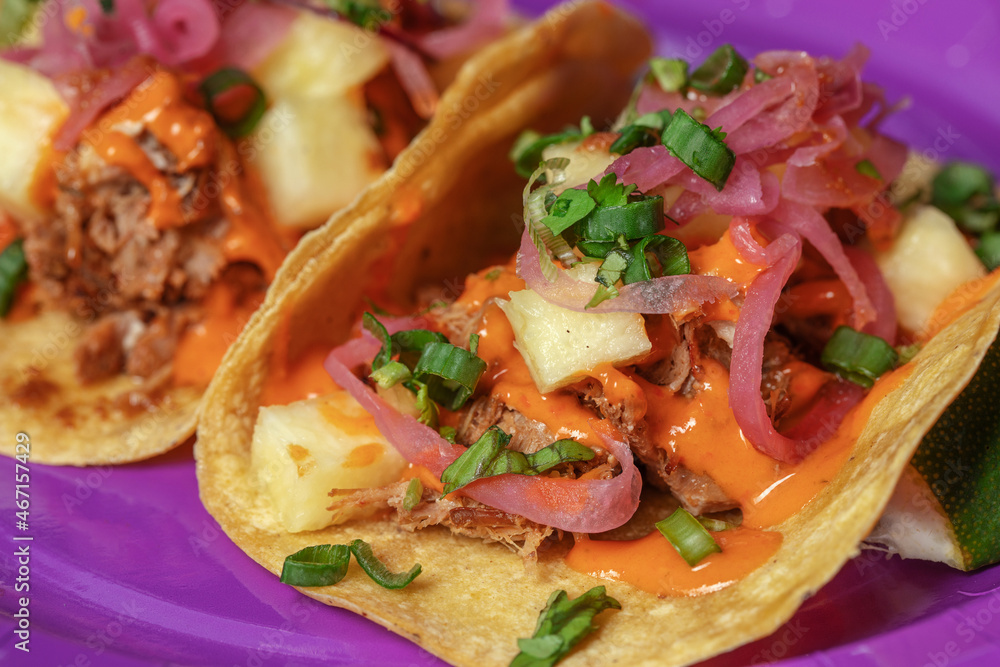 Fototapeta premium Traditional Mexican tacos with meat and vegetables in purple paper plates served for takeaway. Mexican food background.