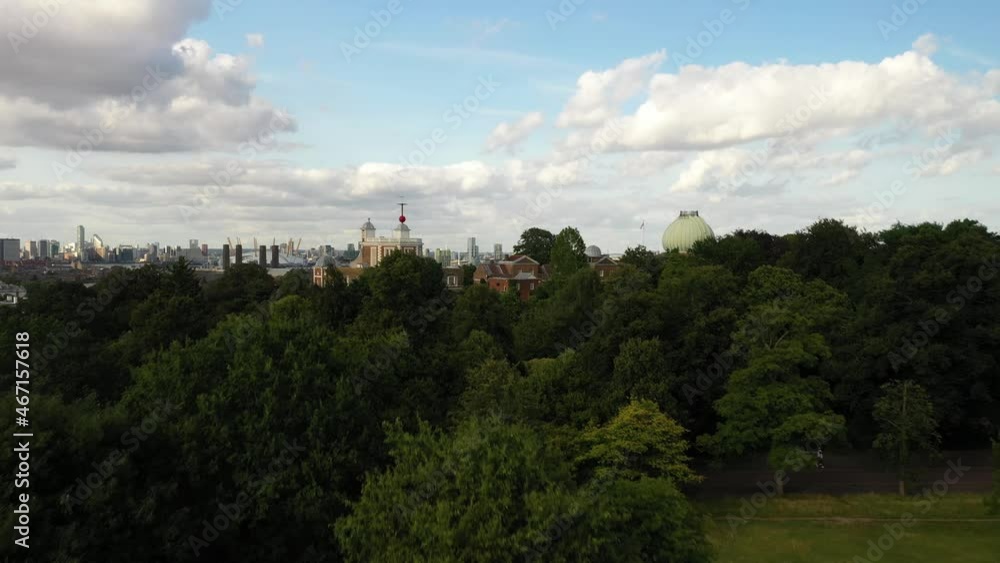 Greenwich observatory, cityscape hiding behind trees in park Greenwich observatory, cityscape hiding behind trees in park