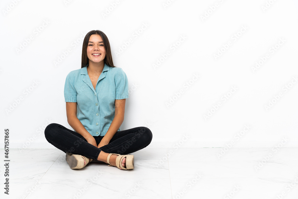 Teenager girl sitting on the floor laughing Teenager girl sitting on the floor laughing