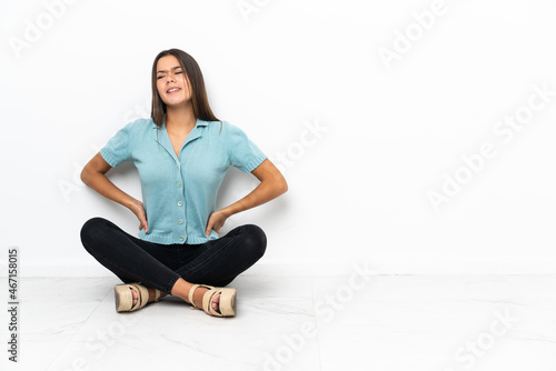 Free Download Teenager girl sitting on the floor suffering from backache for having made an effort - GFXLoad