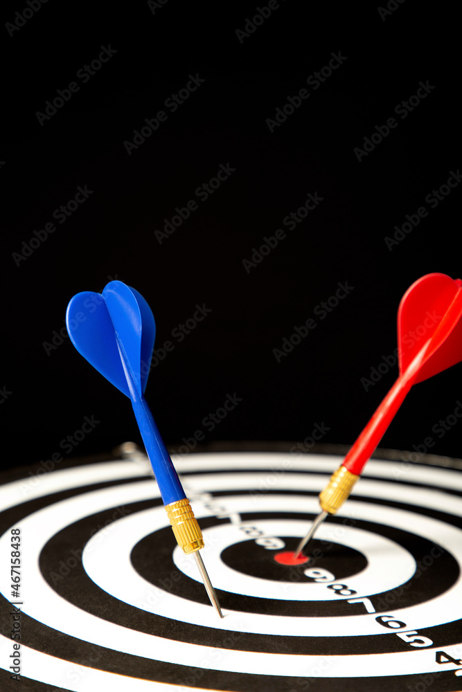 Dart board with darts on black background. Vertical photo. Dart board with darts on black background. Vertical photo.