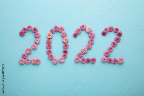 2022 made from fresh flowers on blue background. Happy New Year decoration.