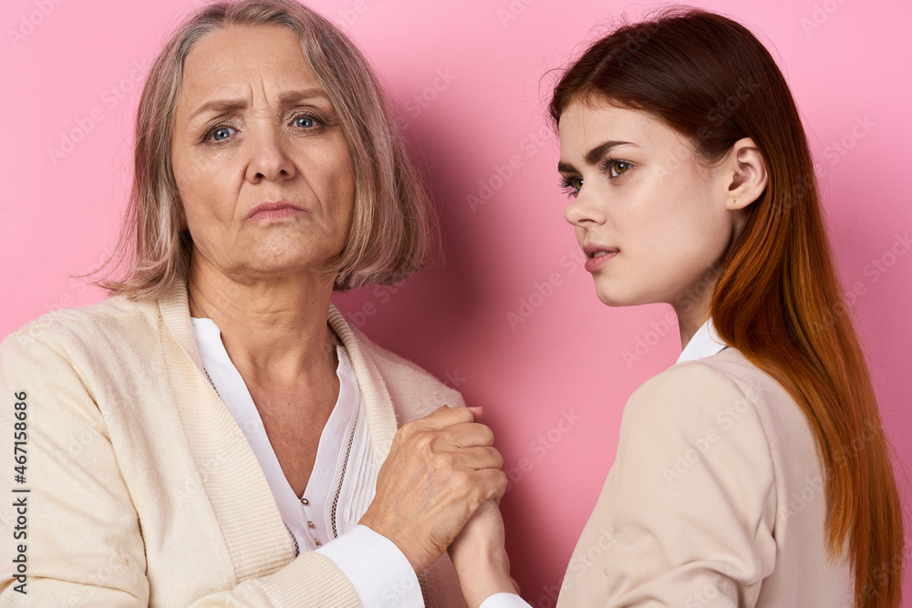 Mom and daughter hug together family caring pink background Mom and daughter hug together family caring pink background