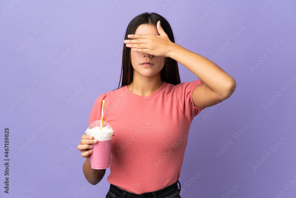 Teenager girl holding a strawberry milkshake covering eyes by hands. Do not want to see something Teenager girl holding a strawberry milkshake covering eyes by hands. Do not want to see something