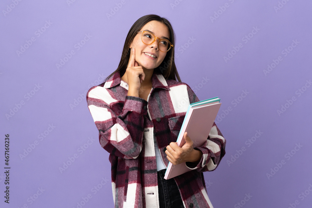 Young student woman isolated on purple background thinking an idea while looking up Young student woman isolated on purple background thinking an idea while looking up