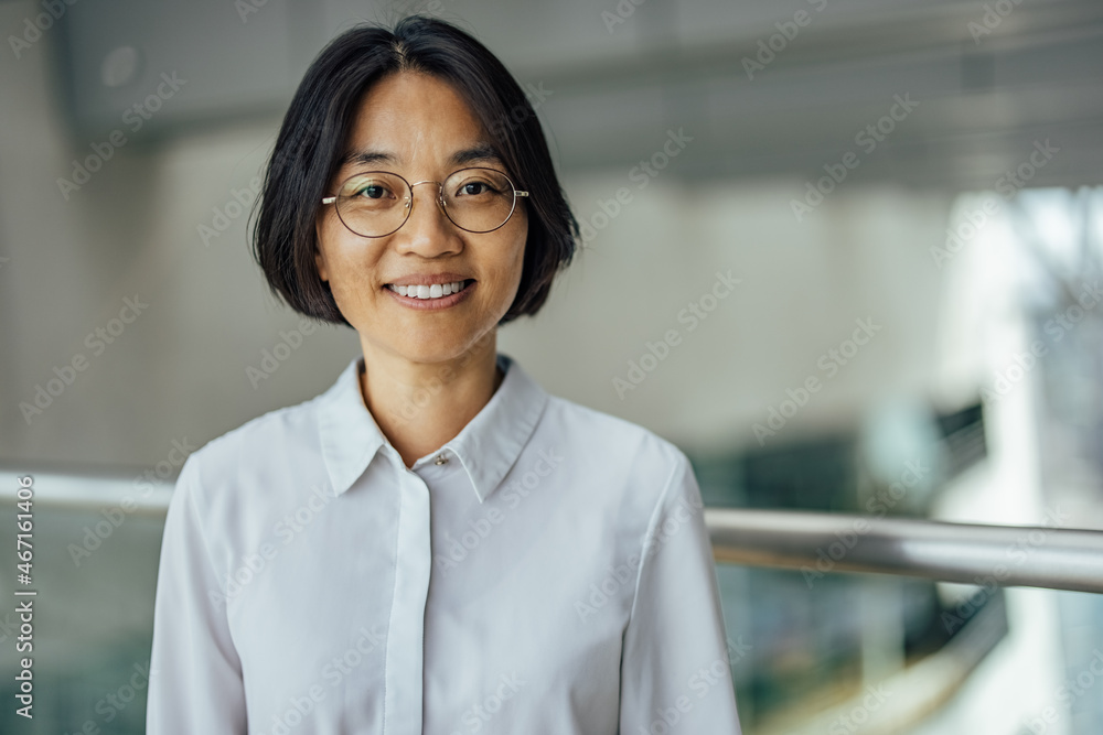 Smiling adult asian woman, representing her company - obrazy, fototapety, plakaty 