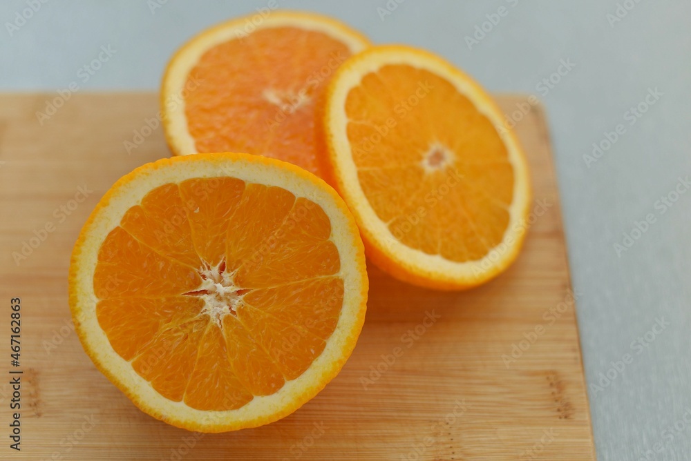 Half and slices of orange on a wooden board. Sliced citrus. A piece of fresh juicy fruit. Half and slices of orange on a wooden board. Sliced citrus. A piece of fresh juicy fruit.
