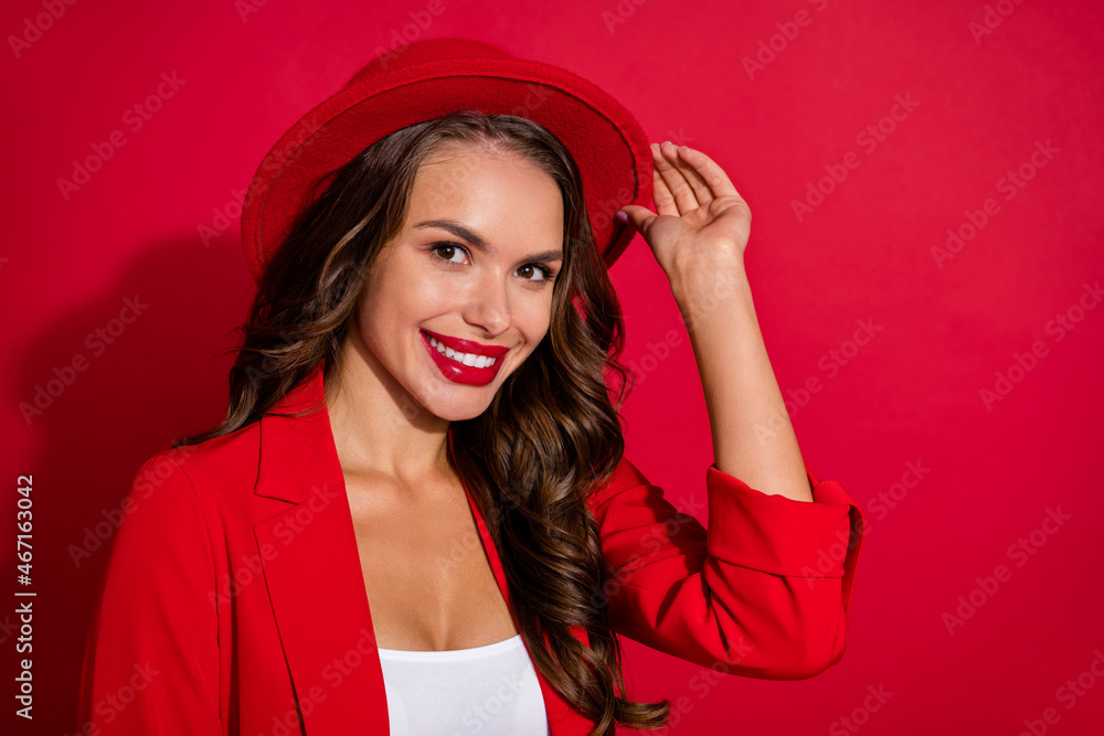 Photo of funny classy young woman wear suit jacket arm cap smiling empty space isolated red color background Photo of funny classy young woman wear suit jacket arm cap smiling empty space isolated red color background